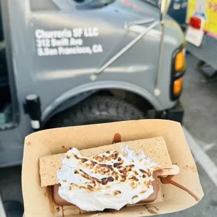 a hand holding a hot dog