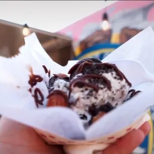 a hand holding a cone of ice cream