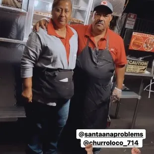 a man and a woman standing in front of a food truck