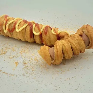 a hot dog wrapped in bacon and mustard