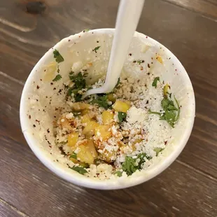 Cup of corn with crema, lime, cheese, and seasoning