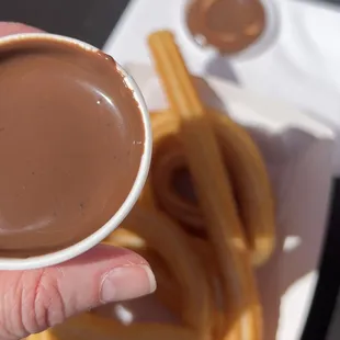 a hand holding a cup of hot chocolate
