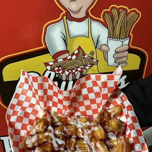 a man holding a basket of churros