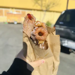 a person holding a bag of churros