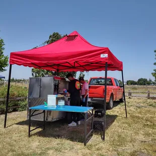 a man standing under a red tent