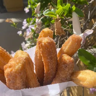 a person holding a basket of churros