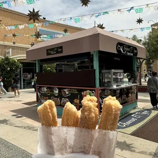 a person holding a bag of churros