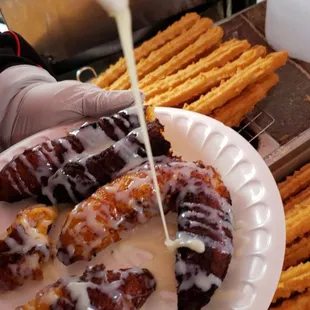a plate of churros being drizzled