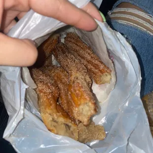 a person holding a bag of churros
