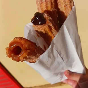a person holding a bag of churros