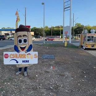a man holding a sign that says churrostar here