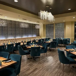 a dining room with blue chairs and a chandelier