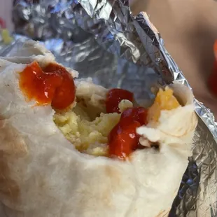 Breakfast burrito with bacon and hot sauce