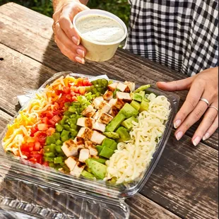 The Mexi-Cobb Salad - the perfect to-go lunch. Fajita chicken, green chiles, cheese, avocados &amp; tomatoes on a bed of fresh salad mix.