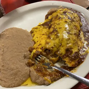 Combination Burrito and refried beans with two bites taken out