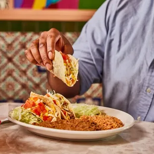 Crispy Tacos - hand-formed corn tortillas filled with seasoned ground sirloin, cheese, lettuce, and tomatoes.