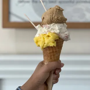 a hand holding a cone of ice cream