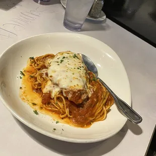 a plate of spaghetti with sauce and parmesan cheese