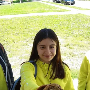 a girl holding a cookie
