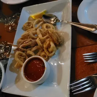 a plate of fried squids and dipping sauce