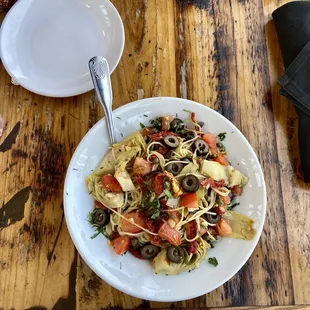 a plate of pasta with tomatoes and olives