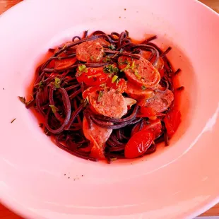 a bowl of pasta with sausage and tomatoes