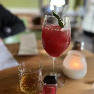 a glass of wine and a bottle of liquor on a table