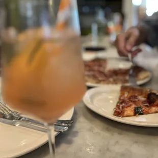 a glass of wine and a plate of pizza