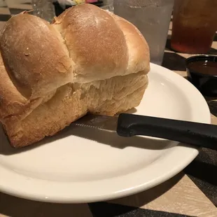 a loaf of bread on a plate with a knife