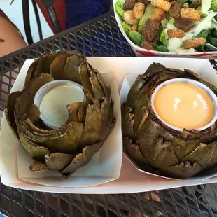 two plates of artichokes and a salad