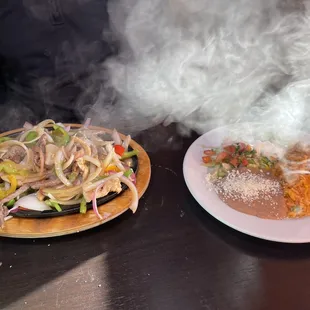 Chicken and steak fajitas and toppings, rice and beans