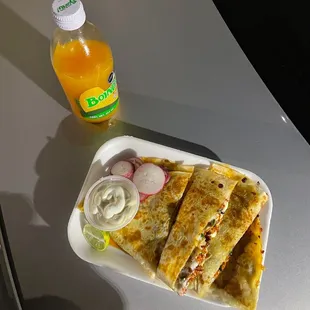 a plate of quesadillas and a bottle of orange juice