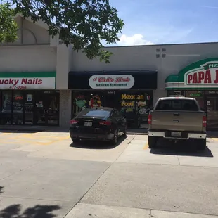 two cars parked in front of a papa johns