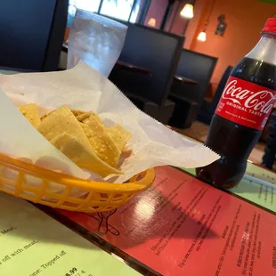 a basket of chips and a bottle of coke