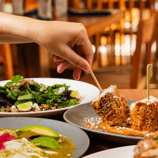 a person picking a piece of food from a plate