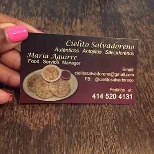 a woman's hand holding a business card