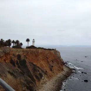 a lighthouse on a cliff overlooking the ocean
