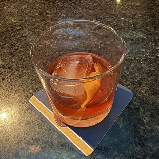a glass of whiskey on a coaster