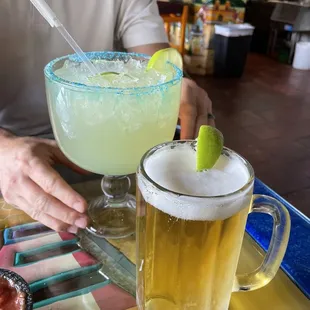 a man sitting at a table with two drinks