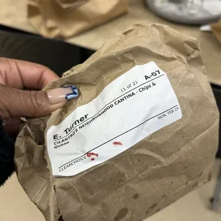 a person holding a bag of food