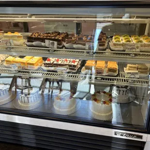 a variety of cakes in a display case