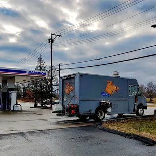ows a delivery truck at a gas station