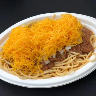 a plate of spaghetti topped with cheese