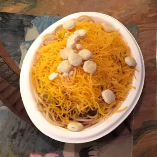 a bowl of spaghetti with cheese and cashews