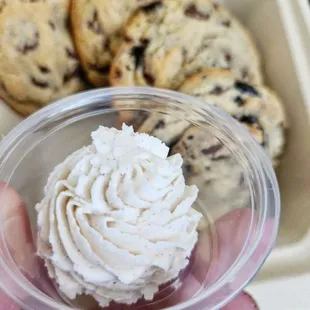 a hand holding a cup of whipped cream