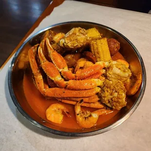 crab legs, corn, and potatoes in a bowl
