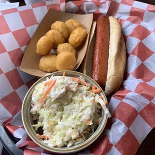 Kids hotdog with slaw on the side and a side of corn nuggets