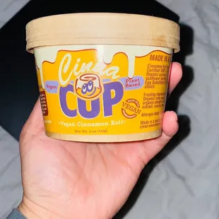 a hand holding a cup of ice cream