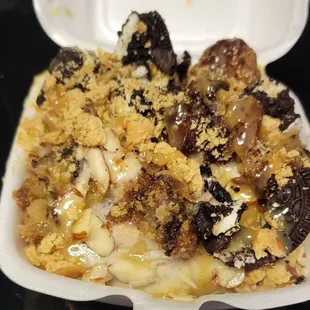 Banana nut bread bites, sliced almonds, strong cookies, graham cracker crumbs, almond icing, and caramel sauce drizzle.