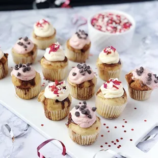 a plate of cupcakes with frosting and sprinkles